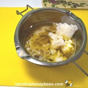Dandelion oil and beeswax added to coconut oil in melter pot image.