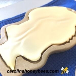 Molded beeswax ornament cooling in mold image.