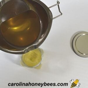 Pouring beeswax vapor rub recipe into containers image.