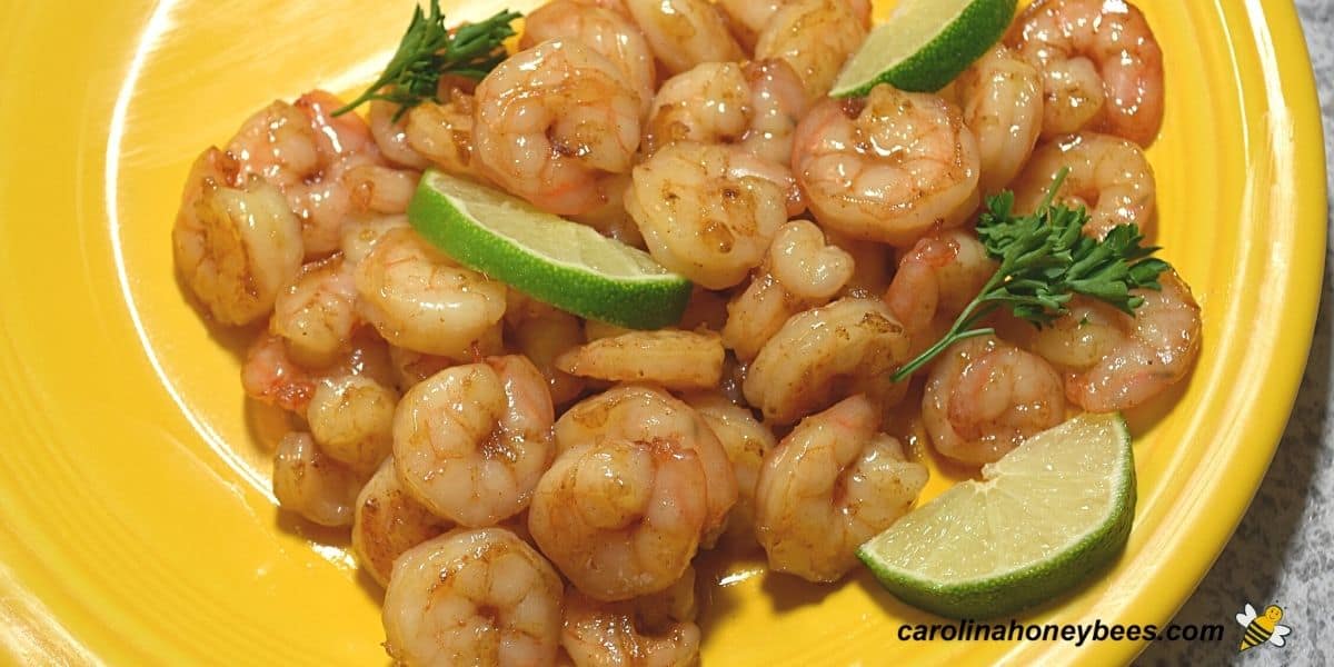 Ingredients of shrimp, garlic, honey, and lime stir fry recipe on a yellow plate.