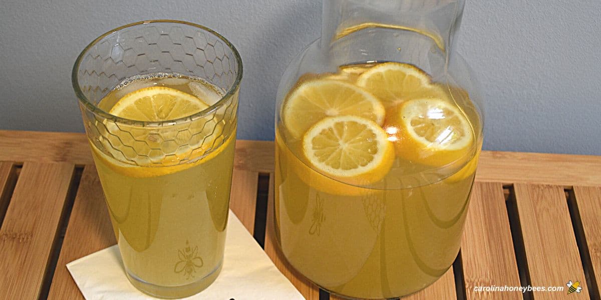 Fresh glass of homemade honey sweetened lemonade and pitcher.