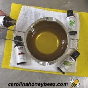 Adding essential oils to beeswax vapor rub recipe image.